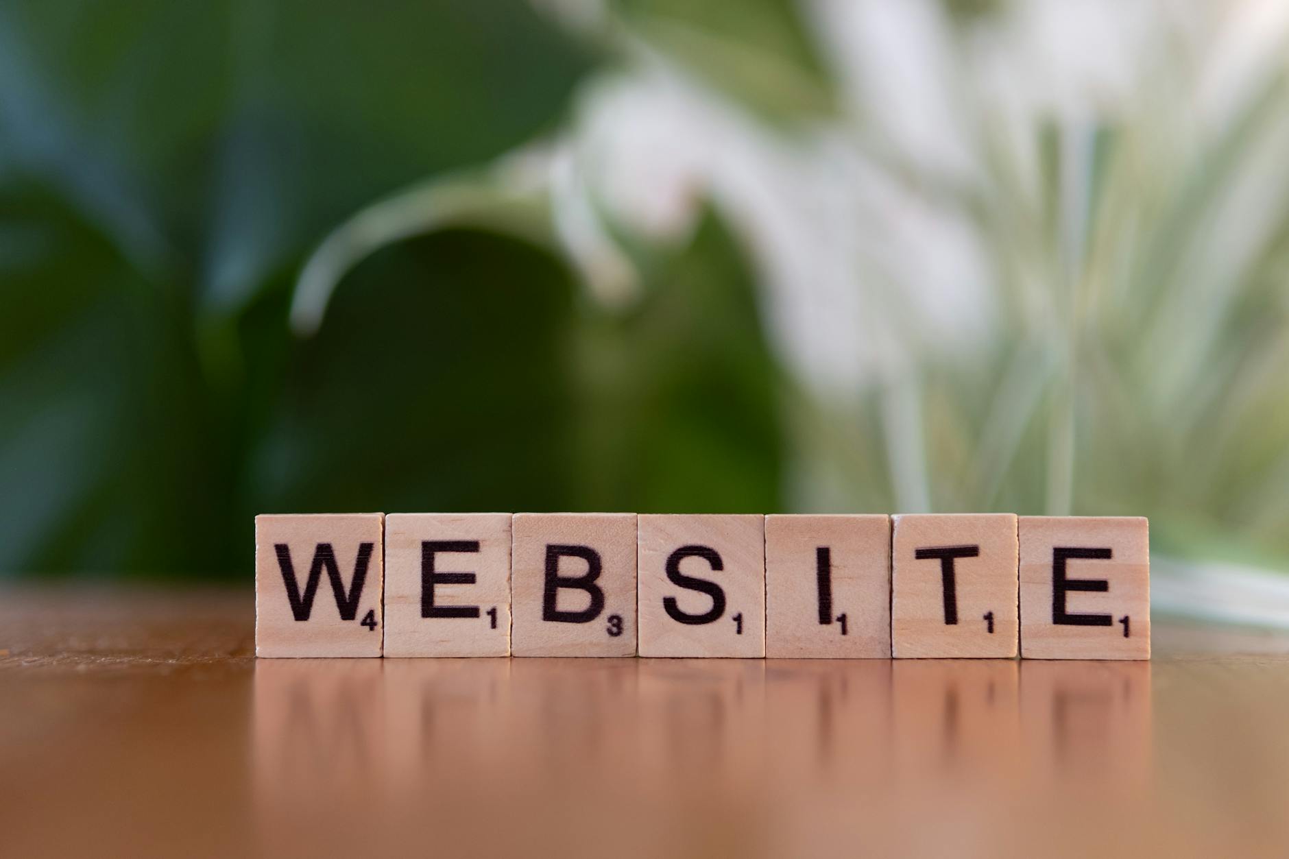 scrabble tiles spelling website on wooden surface